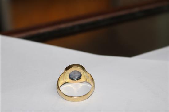 An engraved yellow metal and cabochon star sapphire ring, size O.